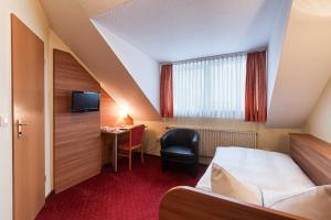 a hotel room with a bed and a desk at Hotel Nürnberger Trichter in Nuremberg