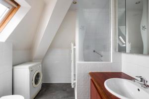 a bathroom with a sink and a washing machine at Le Chateaubriand by Cocoonr in Saint Malo
