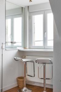 two bar stools in a room with two windows at Le Chateaubriand by Cocoonr in Saint Malo