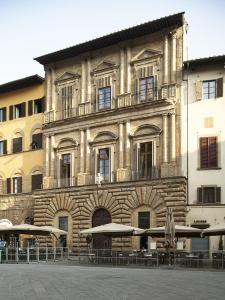 ein Gebäude mit Tischen und Sonnenschirmen davor in der Unterkunft Signoria apartment in Florenz