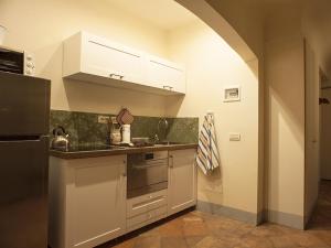 eine Küche mit weißen Schränken und einem schwarzen Kühlschrank in der Unterkunft Signoria apartment in Florenz