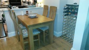 een houten tafel met vier stoelen en een wijnkelder bij Bonny Colne On The Hill in Colne