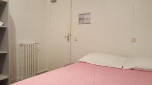 a bedroom with a bed with a pink blanket at Hotel Feria (FR) in Clichy