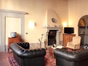 a living room with two leather couches and a fireplace at Apartment Tornabuoni in Florence