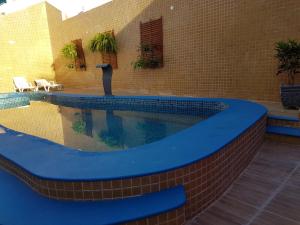 a swimming pool with a blue coping in a building at Pousada Princesa in Arraial do Cabo