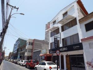 una calle de la ciudad con coches aparcados en la calle en Hotel Velero Centro, en Iquique