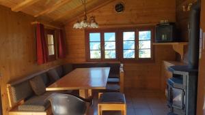 a dining room with a wooden table and chairs at Chalet Marina in Albinen