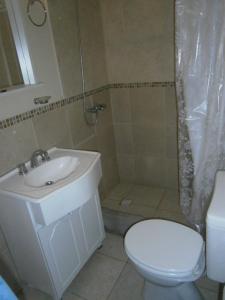 a bathroom with a sink and a toilet and a shower at Acutun in Mar de Ajó +25 photos