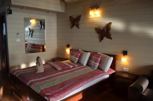 a bedroom with a bed with two butterflies on the wall at Besof Haderech in Misgav ‘Am +27 photos