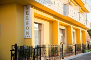 アルバ・アドリアティカにあるNelson Hotelの黄色の建物