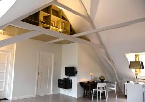 a living room with aamed ceilings and a table and chairs at Zzzuite25 in Oosterhout