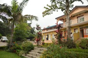 a house with trees and flowers in front of it at Ubumwe Hotel in Gisenyi