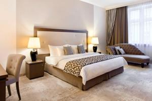 a hotel room with a large bed and a chair at Metropolitan Boutique Hotel in Krakow +33 photos