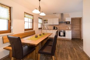 a kitchen with a wooden table and chairs at Biobauernhof Obereck in Göstling an der Ybbs