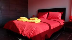 a bedroom with a red bed with towels on it at Dezo Luxury town Apartment in Larnaka +42 photos