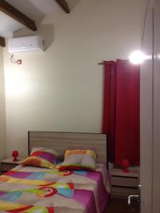 a bedroom with a bed and a red curtain at Gites Man-non in Sainte-Anne
