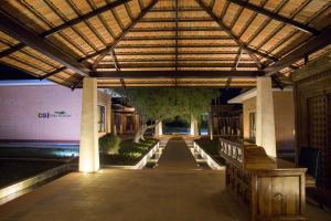 a pergola with a bench in front of a building at Miraaya Wellness and Golf Resort in Chitwan