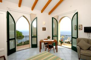 a room with a balcony with a table and chairs at La Dolce Vita Ravello in Ravello