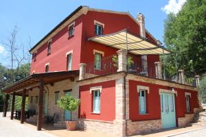 een rood gebouw met een balkon erboven bij Casa Sacciofa in Monte Rinaldo