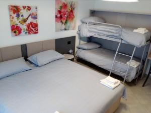 ボルソ・デル・グラッパにあるSalvia e Timo Roomsのベッド2台が備わる客室で、壁には絵画が飾られています。
