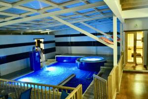 a large swimming pool in a room with blue lighting at Hotel El Giro in Villa de Leyva