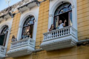 a group of people looking out of the windows of a building at The Clock Hostel & Suites in Cartagena de Indias