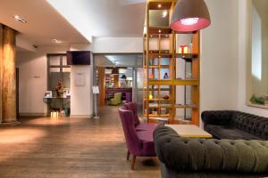 a lobby with couches and a table and chairs at Ambassadors Bloomsbury in London