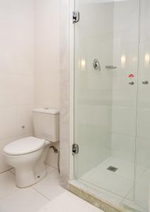 uma casa de banho com um WC e uma cabina de duche em vidro. em ibis Vitoria da Conquista em Vitória da Conquista