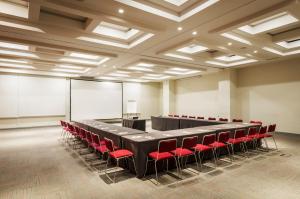 una sala conferenze con un lungo tavolo e sedie rosse di Hotel Riazor Aeropuerto a Città del Messico Altre 9 foto