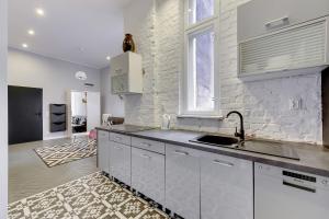 a kitchen with a sink and a white brick wall at Blue Mandarin Solidarity Square in Gdańsk