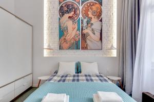 グダニスクにあるBlue Mandarin Solidarity Squareのベッドルーム1室(ベッド1台付)が備わります。壁には絵画が飾られています。
