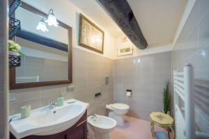 ein Badezimmer mit einem Waschbecken, einem WC und einem Spiegel in der Unterkunft La Regina di Vertecoeli in Neapel