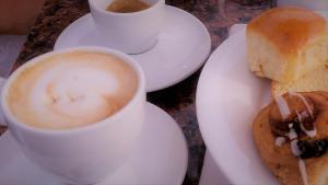 a plate with a cup of coffee and a doughnut at Burlamacco Gold in Viareggio