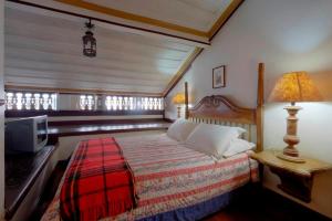 ein Schlafzimmer mit einem Bett und einem Fernseher darin in der Unterkunft Casa Figueira da Foz in Ouro Preto