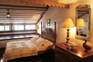 ein Schlafzimmer mit einem großen Bett und einem Spiegel in der Unterkunft Casa Figueira da Foz in Ouro Preto