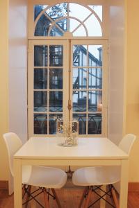 una mesa blanca con sillas blancas y una ventana en Lost Apartments, en Oporto