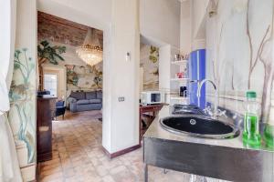 a kitchen with a sink and a living room at Palazzo Giorgioli Apartment in Rome