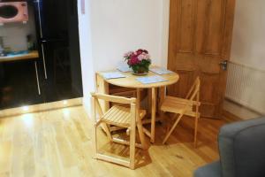 a small table with two chairs and a vase of flowers on it at The Lookout in Helensburgh