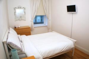 a small bedroom with a bed and a window at The Lookout in Helensburgh