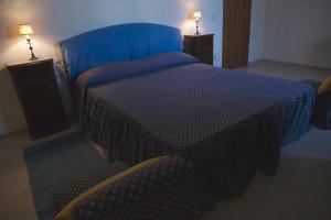 um quarto com uma cama com um edredão azul em Masseria Rosario em Grottaglie