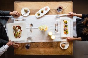 um grupo de pessoas sentadas à volta de uma mesa com comida em ElisabethHotel Premium Private Retreat- Adults only em Mayrhofen