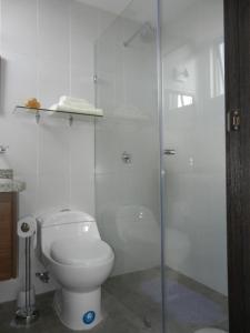 a bathroom with a toilet and a glass shower at Suit Torre Sofia in Quito