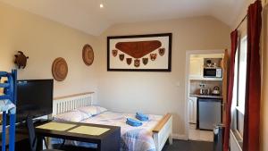 1 dormitorio con cama, escritorio y cocina en Hilltop Seaview Apartment en Wicklow