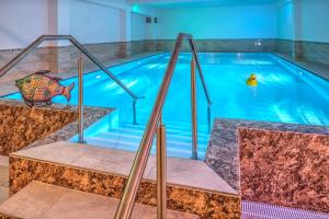 a swimming pool with stairs leading into a swimming pool at Landhotel Schwarzer Adler in Sülzetal