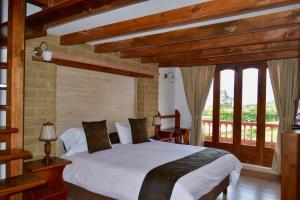 a bedroom with a white bed in a room with windows at Hotel El Giro in Villa de Leyva