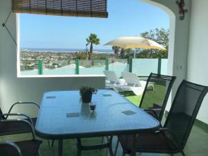 Vista Dorada 7A في ماسبالوماس: طاولة زرقاء مع كراسي ومظلة على الفناء