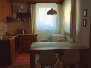 eine Küche mit einem Tisch und Stühlen sowie einem Fenster in der Unterkunft Apartment Kenda in Bovec