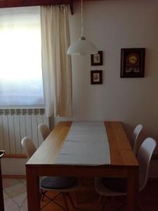 a dining room table with white chairs and a window at Apartment Kenda in Bovec