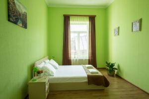 une chambre verte avec un lit et une fenêtre dans l'établissement Vakhtang Gorgasali apartment, à Tbilissi
