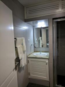 y baño con lavabo y espejo. en Apartamento Faro Sardina, en Sardina